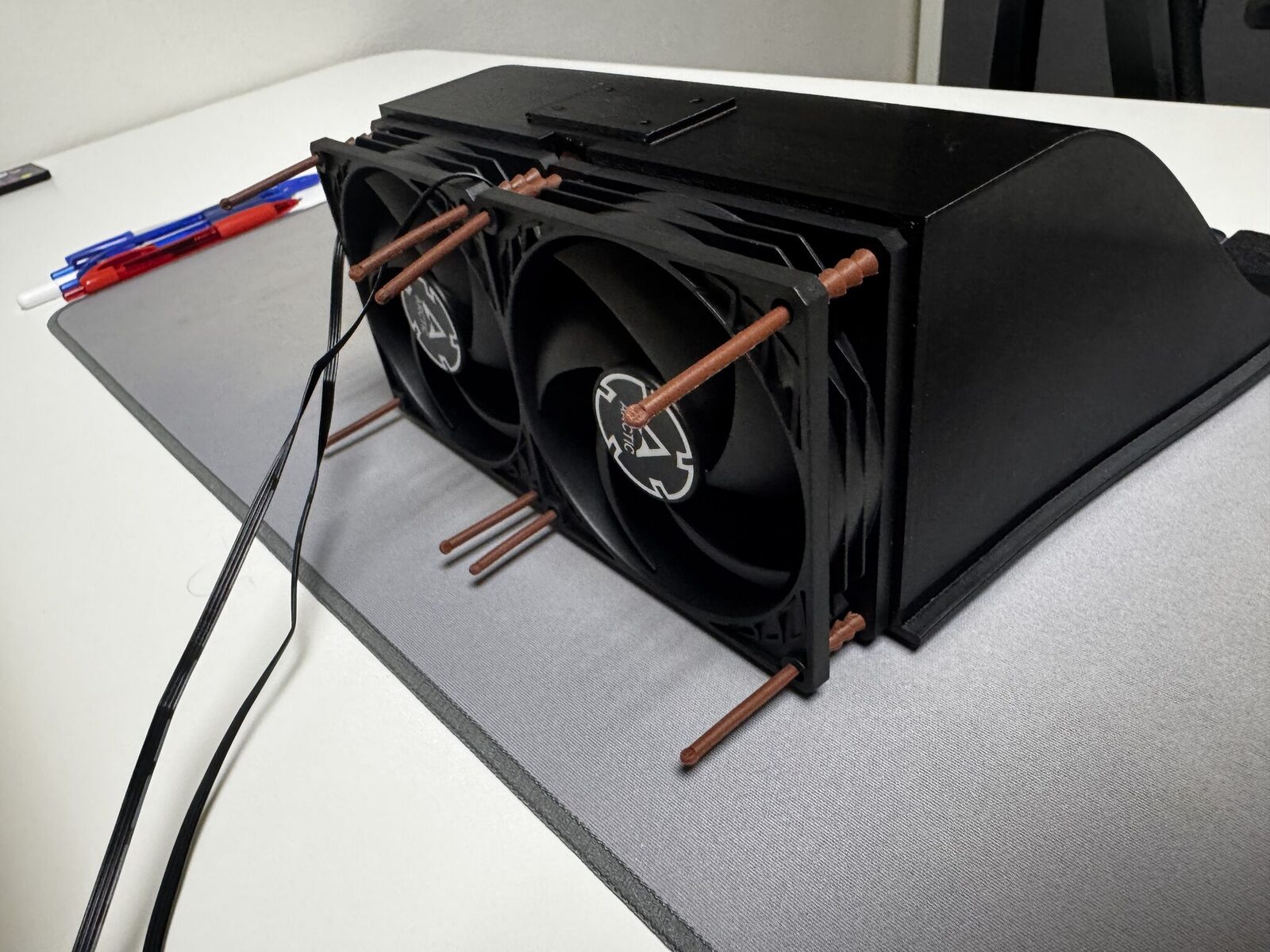Hotový chladicí tunel zezadu: dva ventilátory Arctic P9 uchycené gumovými silentbloky a plošinka pro regulátor na střeše komory